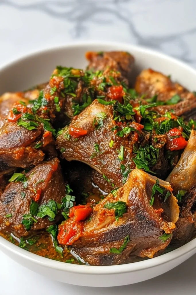 Zarte Lammrippen in würziger Tomatensauce, garniert mit frischen Kräutern.