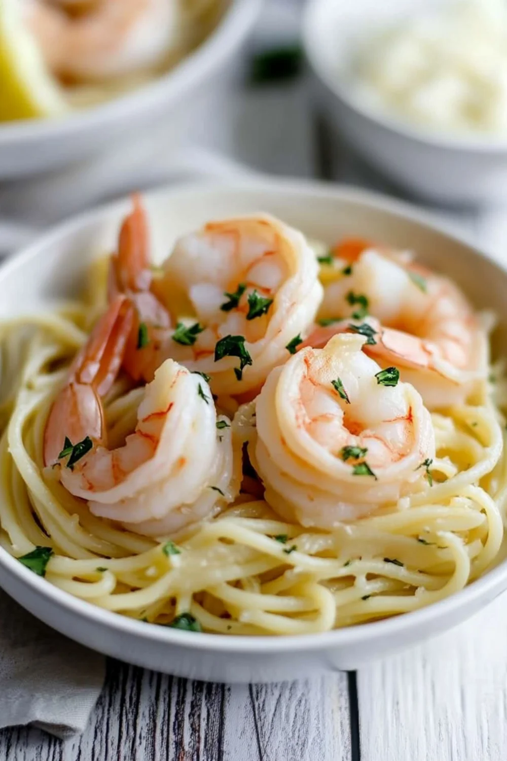 Spaghetti mit Garnelen und frischem Kräuter-Topping in einer Schale.