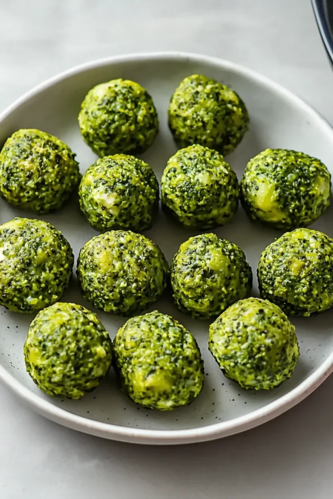 Eine Platte mit kleinen Brokkoli-Ei-Bissen, die goldbraun und lecker aussehen.